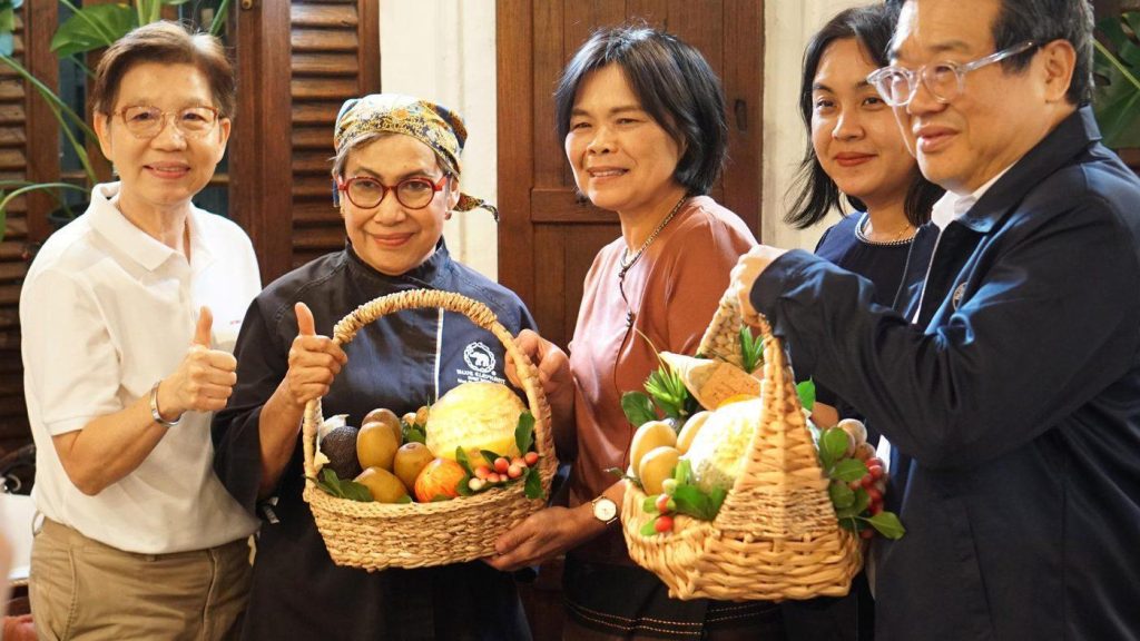 Blue Elephant chef and guests holding baskets of fresh fruit and vegetables