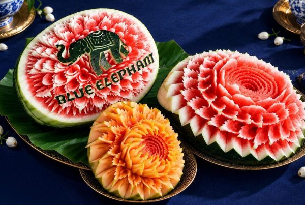Thai fruit carving of watermelon and papaya flowers with the Blue Elephant logo