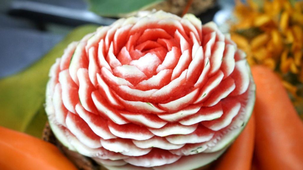 Close-up of a watermelon carved into a detailed rose, an example of Kae Sa Lak